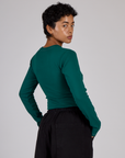 Angled back view of the Hunter Green Long Sleeve Porthole Tee on Mika