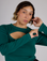 Tiara is 5'4" and wearing XS Hunter Green Long Sleeve Porthole Tee