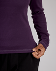 Close up of the Nebula Purple Long Sleeve Porthole Tee's hem worn by Mika