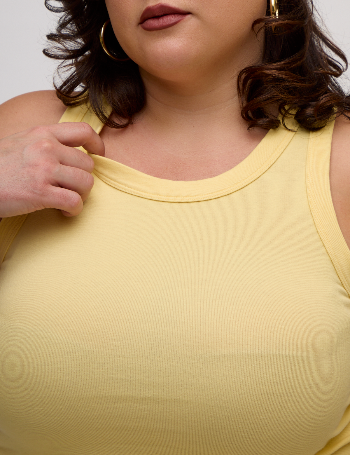 Close up of the Butter Yellow Deep Cut Racerback's neckline worn by Kristen