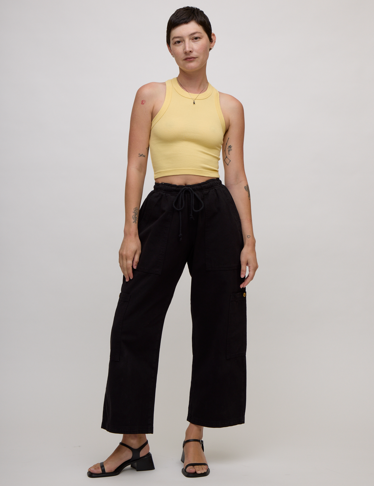 Alex wearing the Butter Yellow Deep Cut Racerback with the Black Drop Pocket Cargo Pant