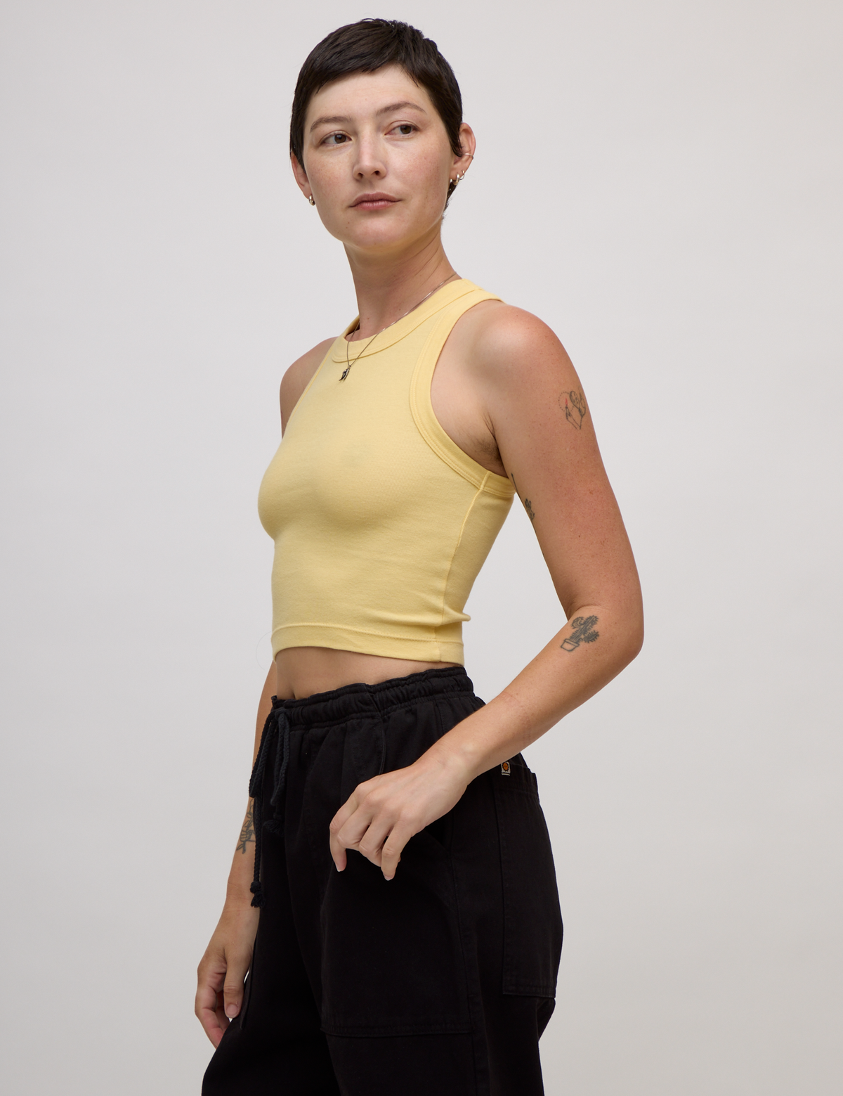 Angled side view of the Butter Yellow Deep Cut Racerback on Alex