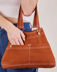 Overall Handbag in burnt terracotta on arm of model