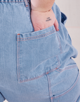 Back pocket close up of Petite Carpenter Jeans in Light Wash. Jordan has their hand in the pocket.