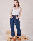 Hana is 5'3" and wearing XXS Petite Carpenter Jeans in Dark Wash paired with a vintage off-white Cropped Tank