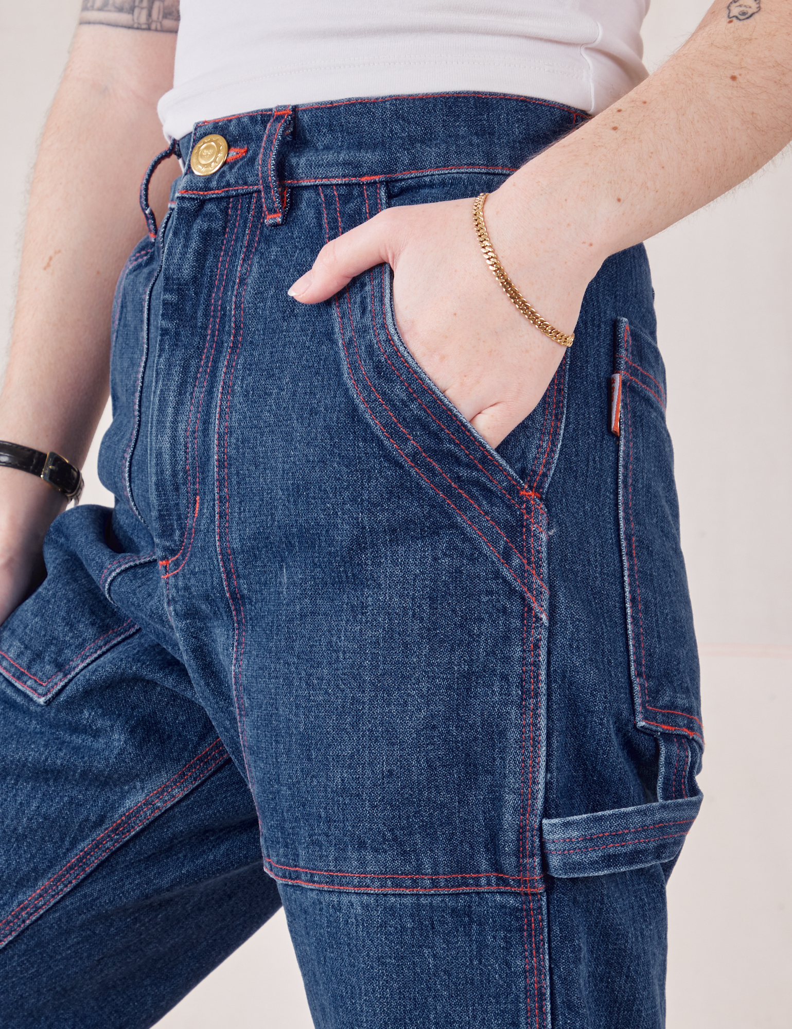 Front pocket close up of Petite Carpenter Jeans in Dark Wash. Hana has her hand in the pocket.