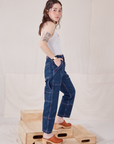 Side view of Petite Carpenter Jeans in Dark Wash and vintage off-white Cropped Tank on Hana