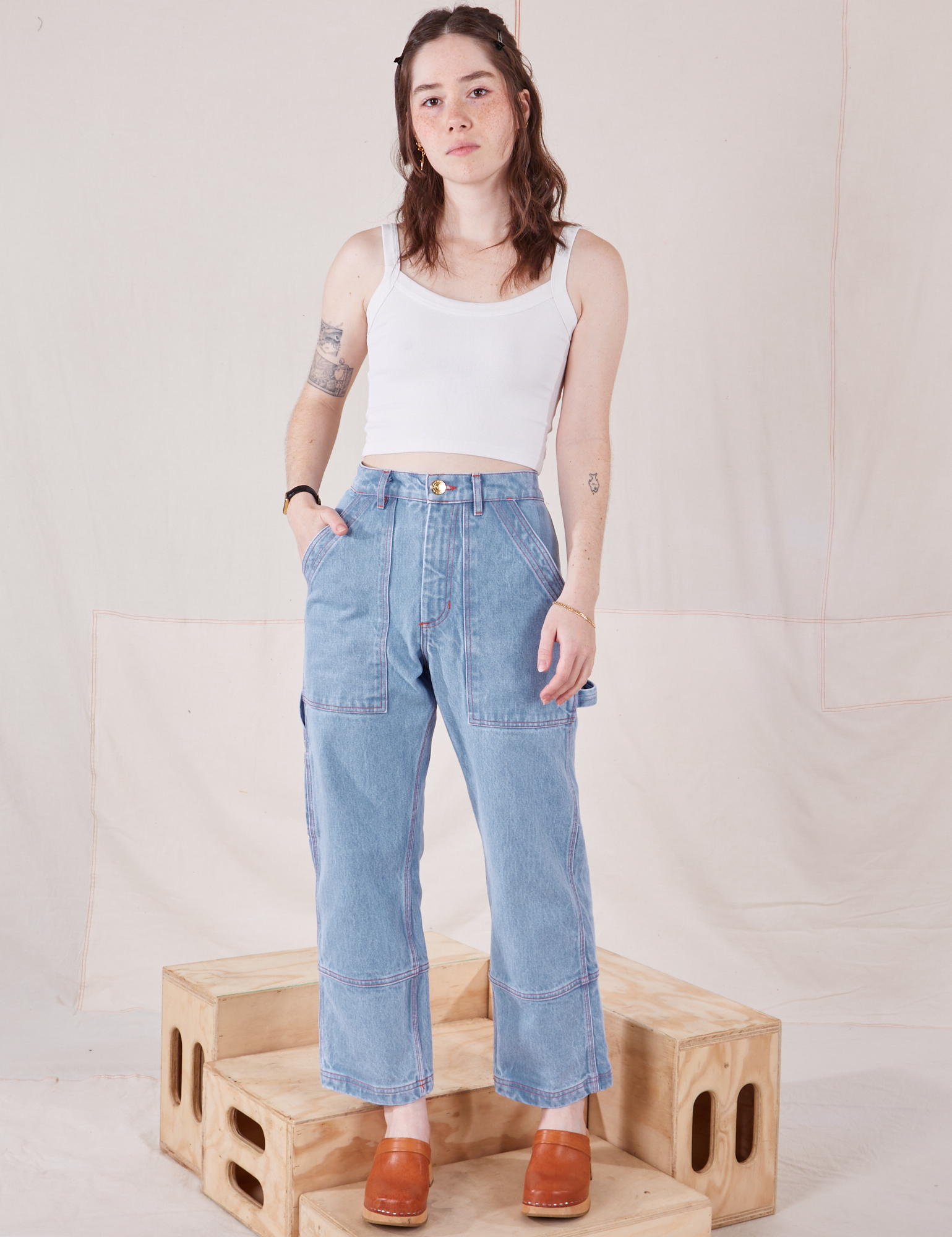 Hana is 5&#39;3&quot; and wearing XXS Petite Carpenter Jeans in Light Wash paired with vintage off-white Cami