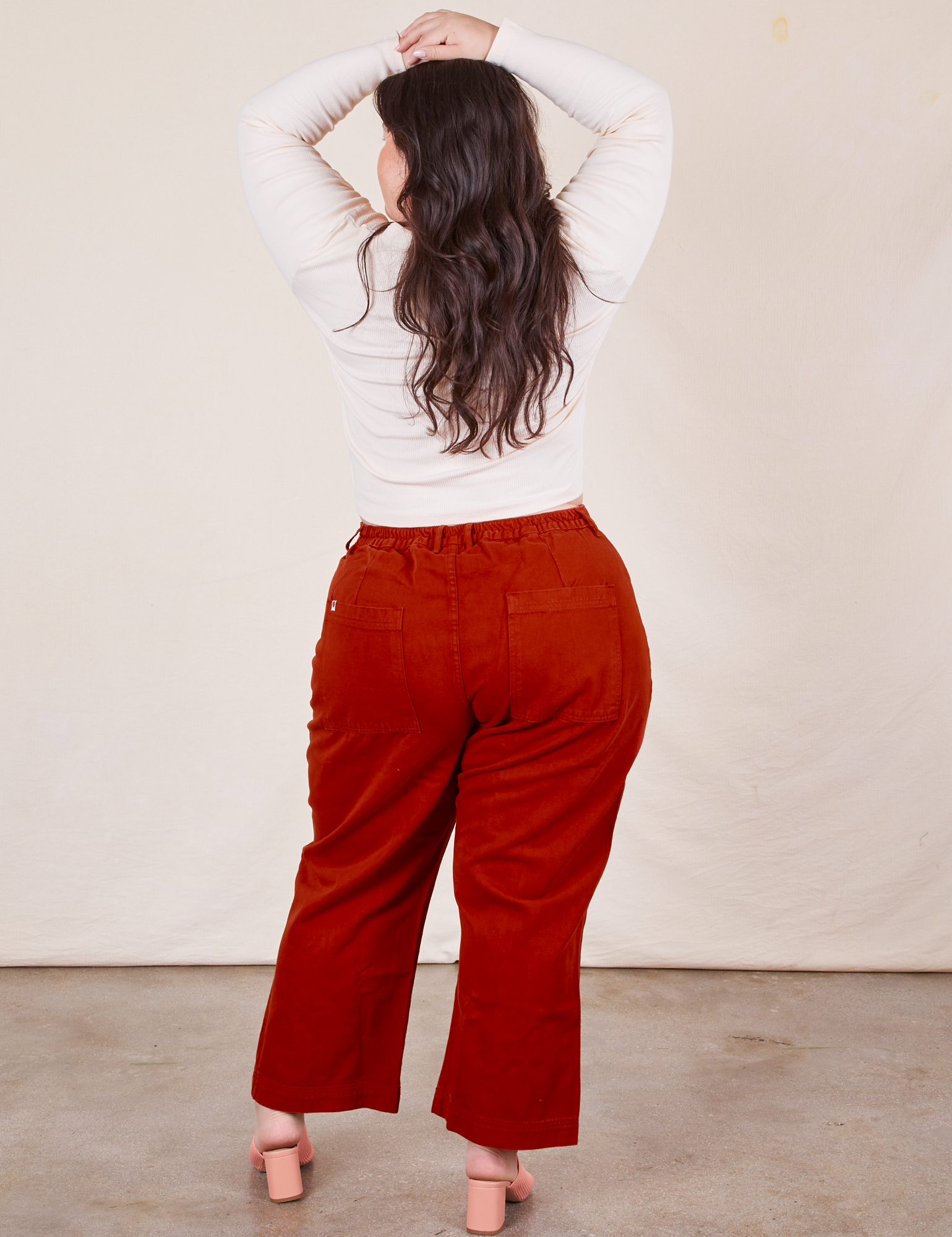Back view of Western Pants in Paprika paired with a vintage off-white Long Sleeve V-Neck Tee worn by Ashley
