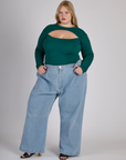 Juliet wearing the Hunter Green Long Sleeve Porthole Tee tucked into Light Wash Denim Wide Leg Trousers