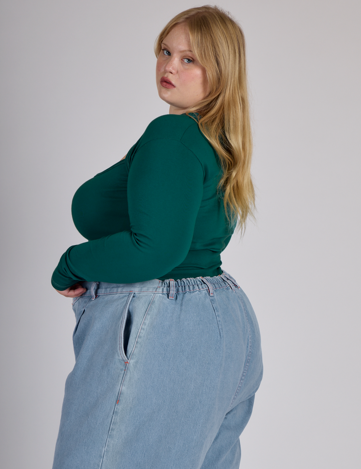 Side view of Juliet wearing the Hunter Green Long Sleeve Porthole Tee