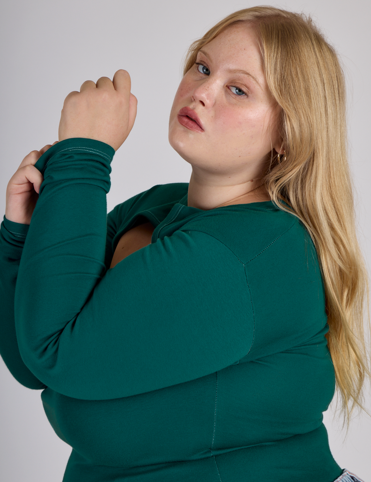 Close up side view of Juliet in the Hunter Green Long Sleeve Porthole Tee
