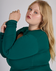 Close up side view of Juliet in the Hunter Green Long Sleeve Porthole Tee