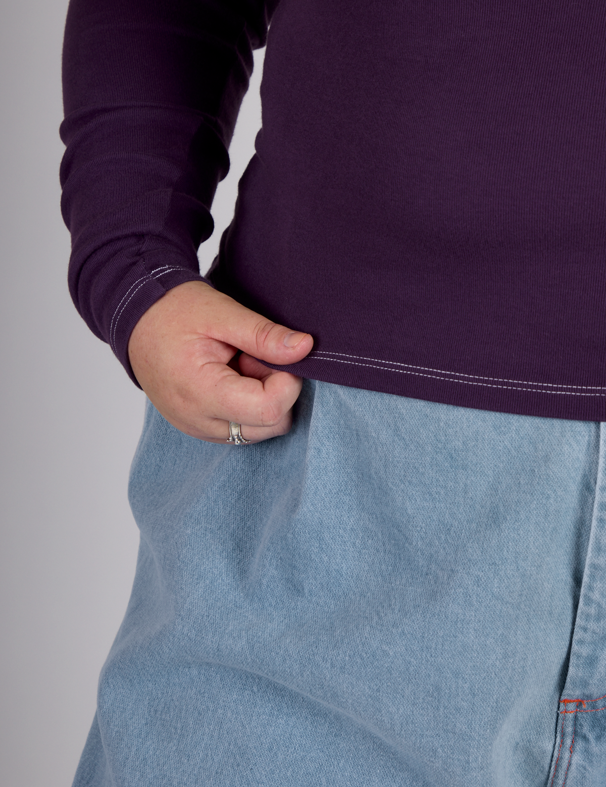 Close up of hem of the Nebula Purple Long Sleeve Porthole Tee worn by Juliet
