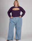 Juliet wearing the Nebula Purple Long Sleeve Porthole Tee tucked into the Light Wash Wide Leg Denim Trousers