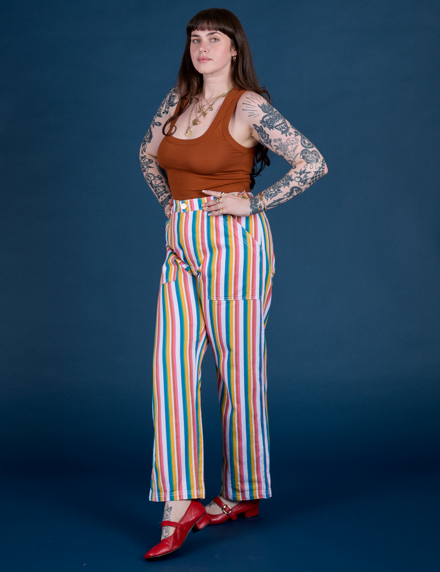 Angled front view of Work Pants in Rainbow Stripe and burnt terracotta Cropped Tank on Sydney