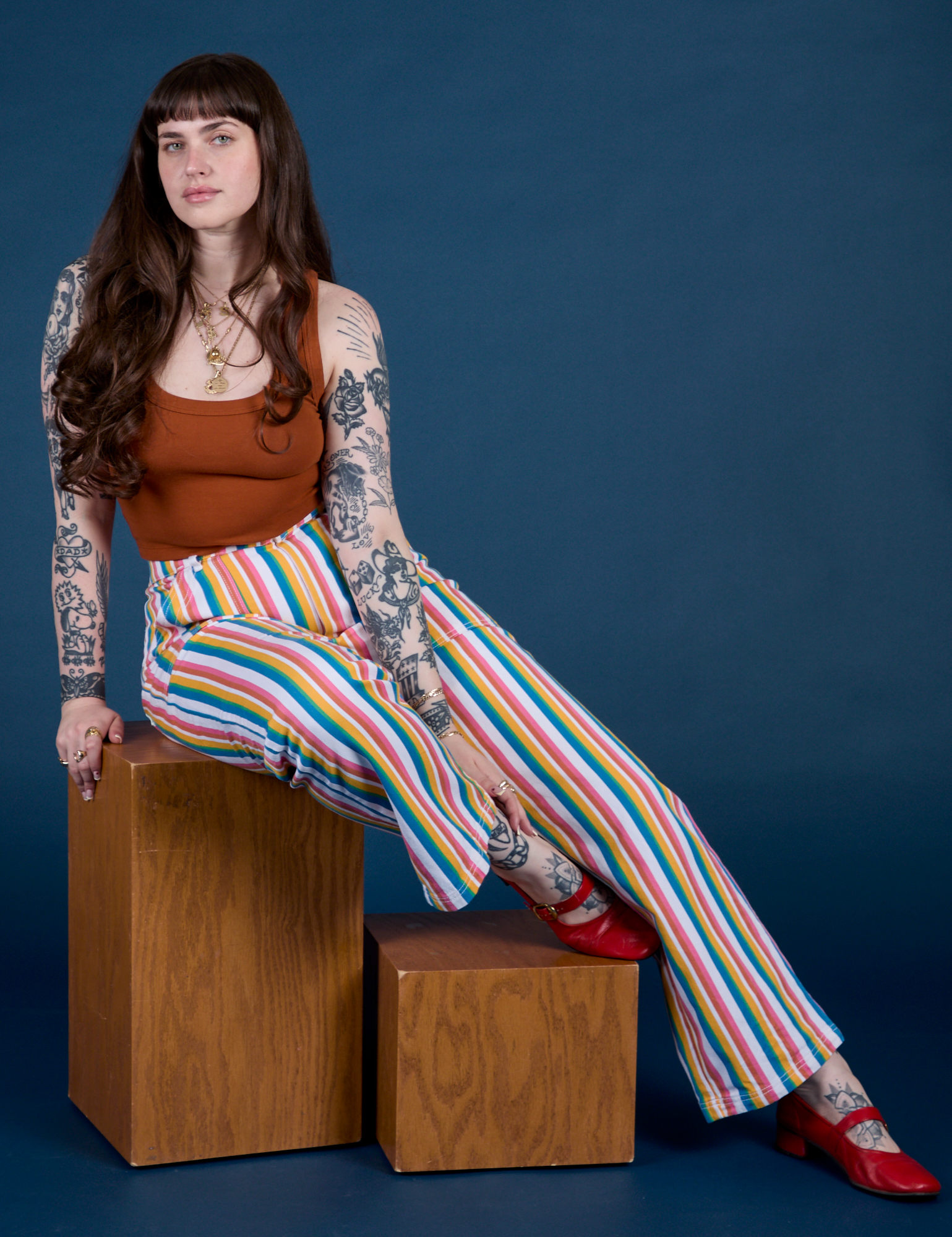 Sydney is wearing Work Pants in Rainbow Stripe and burnt terracotta Cropped Tank