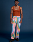 Isaac is wearing Work Pants in Rainbow Stripe and burnt terracotta Cropped Tank