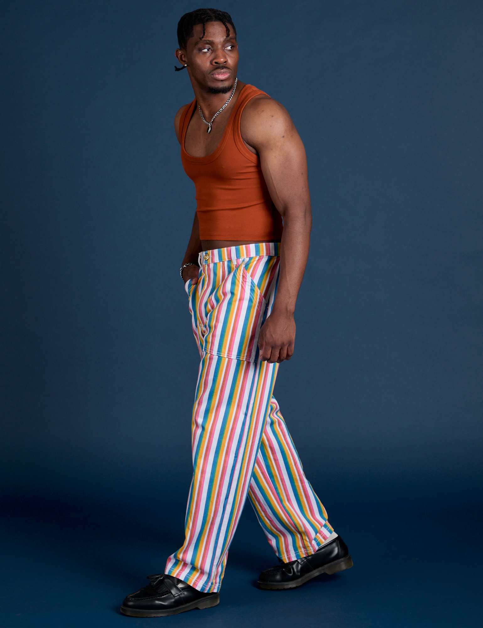 Side view of Work Pants in Rainbow Stripe and burnt terracotta Cropped Tank on Isaac