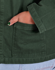 Close up of Morgan's hand in the front pocket of Denim Work Jacket in Swamp Green