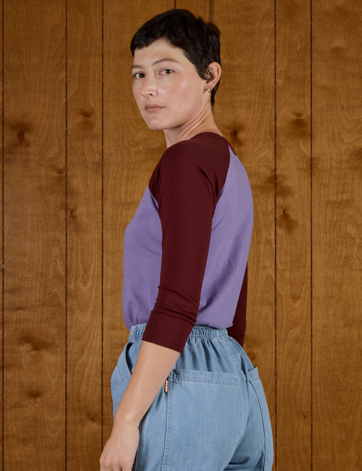 Angled back view of the Faded Grape/Wine Colorblock Raglan Tee on Alex