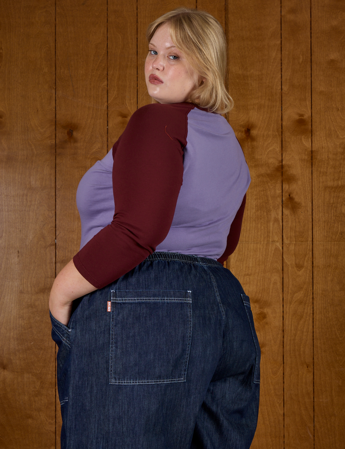 Angled back view of Juliet in the Faded Grape/Wine Colorblock Raglan Tee
