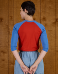 Back view of the Mustang Red/Blue Colorblock Raglan Tee on Alex