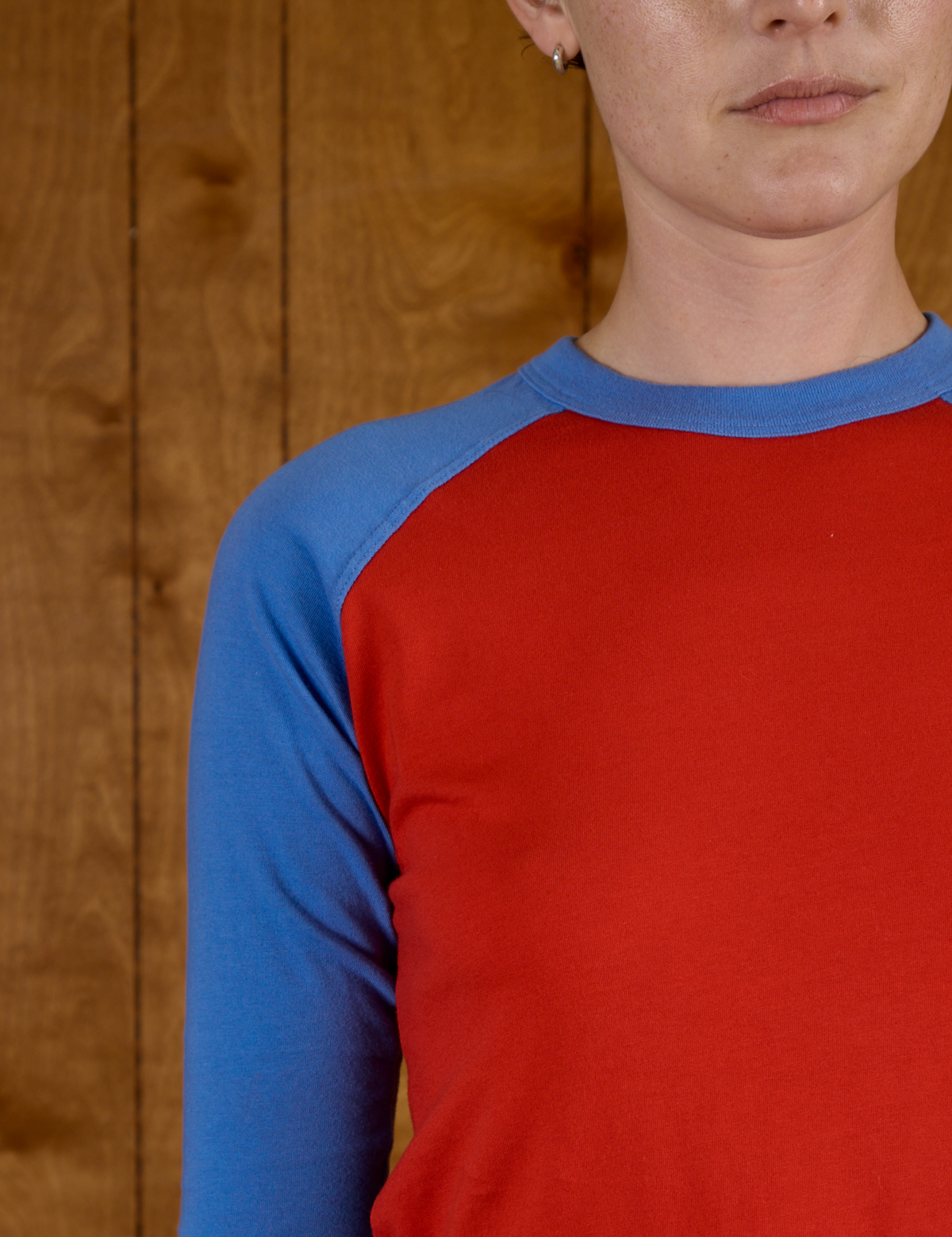 Close up of the Mustang Red/Blue Colorblock Raglan Tee on Alex