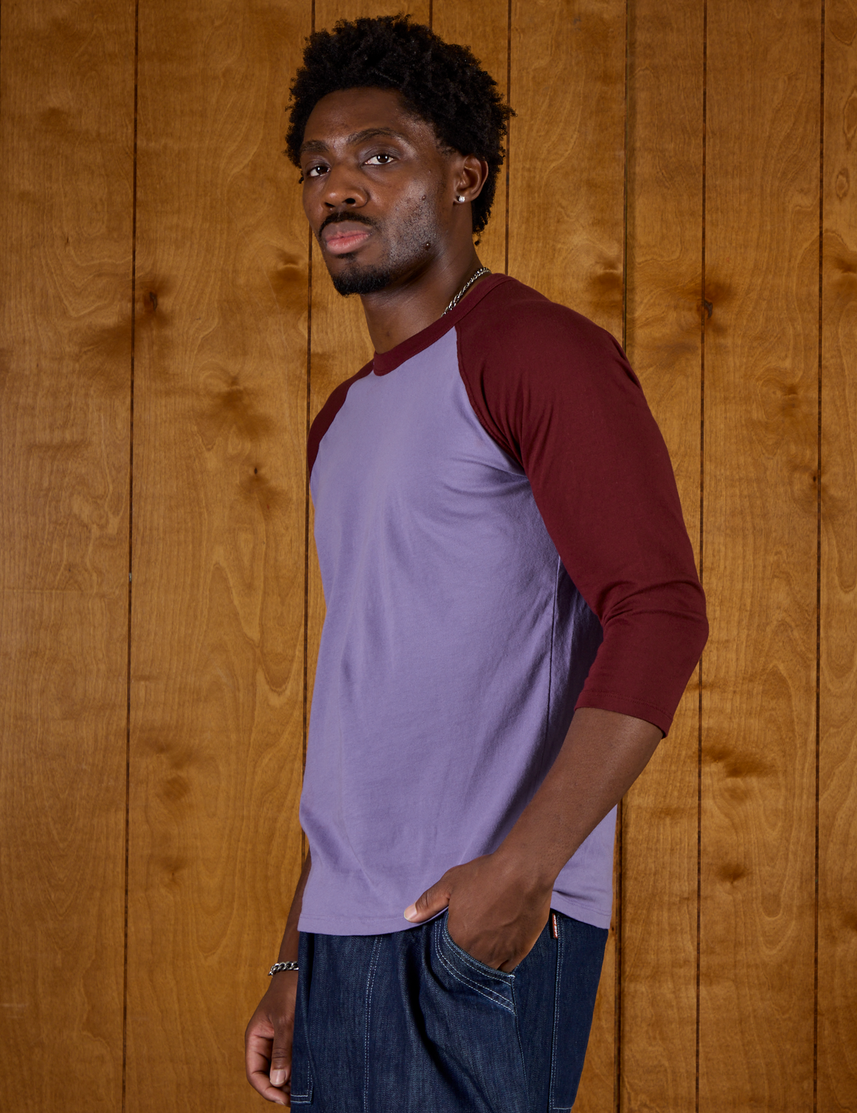 Side view of Isaac in the Faded Grape/Wine Colorblock Raglan Tee