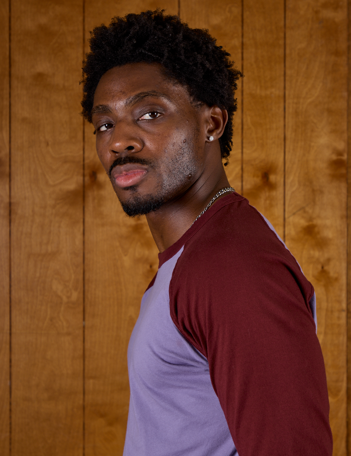 Close up side view of Isaac in the Faded Grape/Wine Colorblock Raglan Tee
