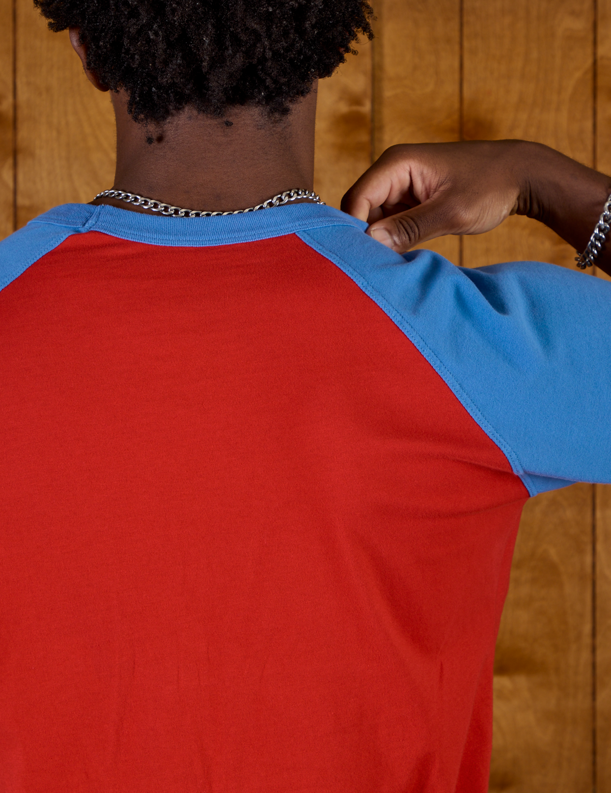 Close up back view of the Mustang Red/Blue Colorblock Raglan Tee on Isaac