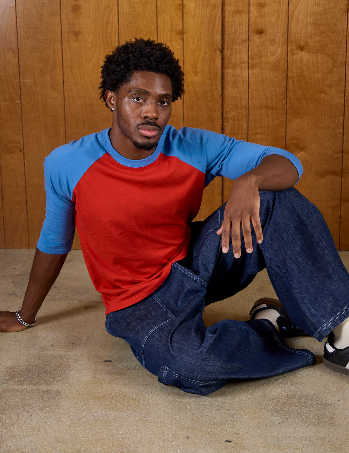 Isaac wearing the Mustang Red/Blue Colorblock Raglan Tee with Dark Wash Denim Drop Pocket Pants