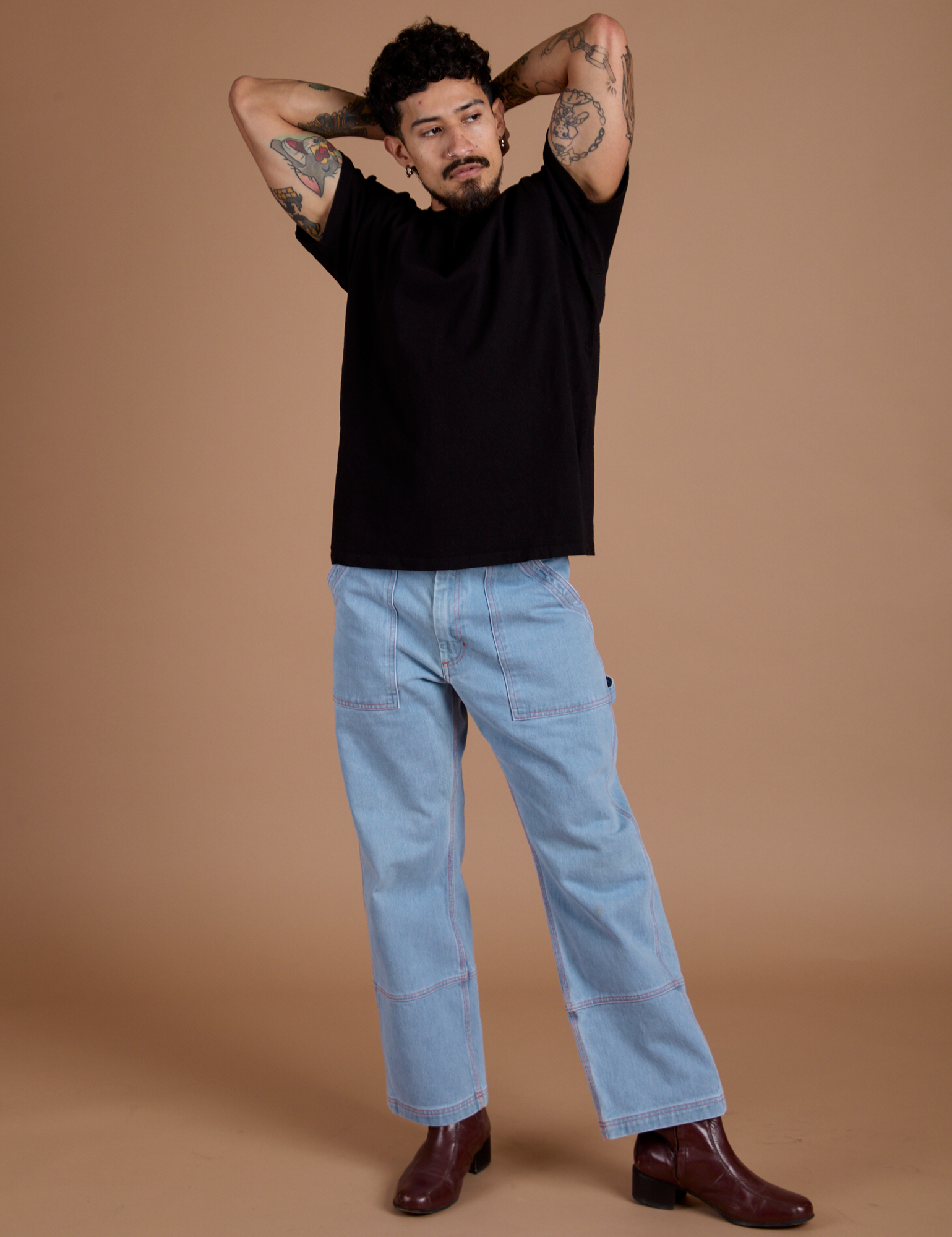 Jesse is 5'8" and wearing S Burly Tee in Basic Black paired with light wash Carpenter Jeans