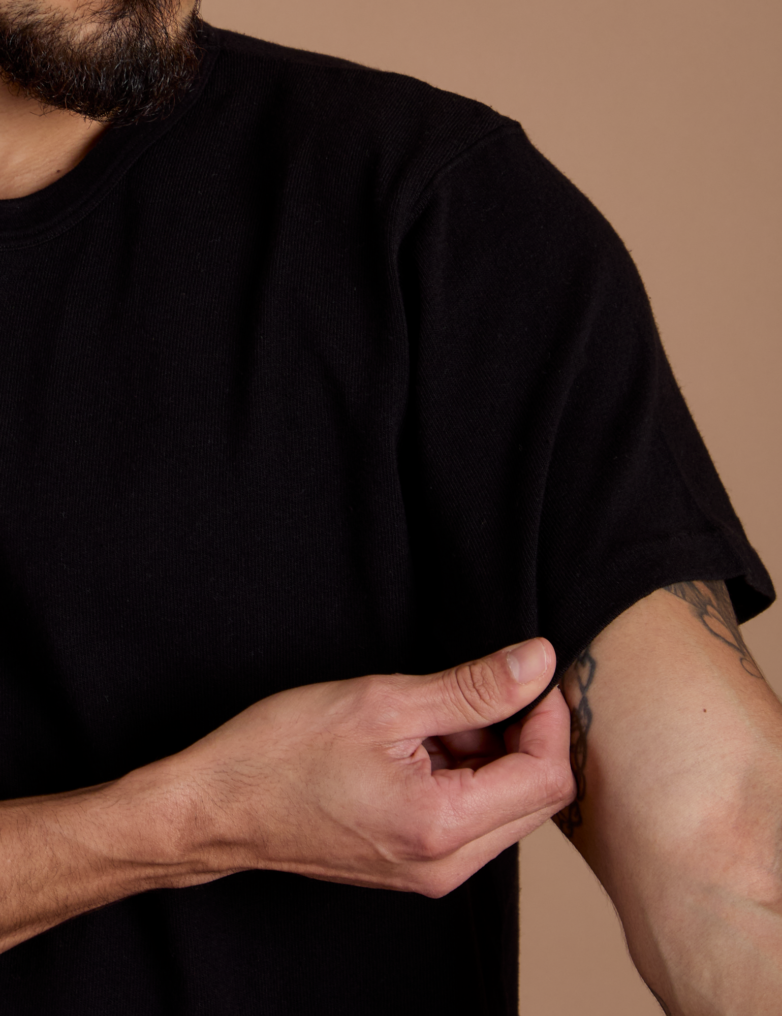 Close up of Burly Tee in Basic Black sleeve on Jesse