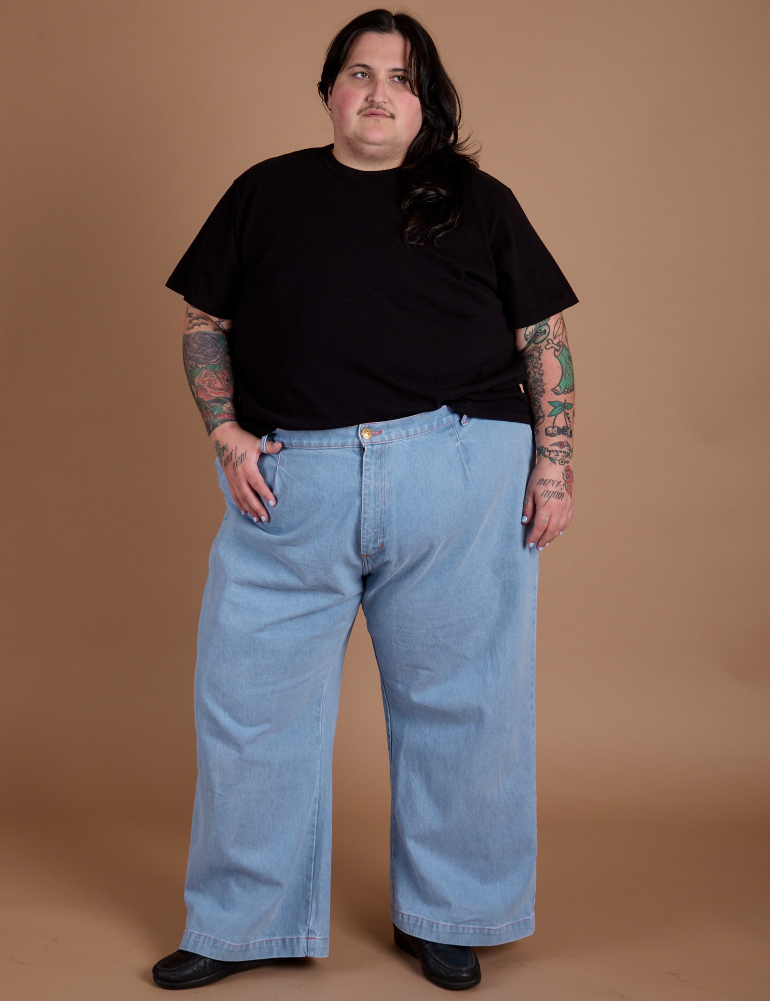 Sam is 5'10" and wearing 2XL Burly Tee in Basic Black paired with light wash Indigo Wide Leg Trousers