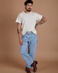 Jesse is 5'8" and wearing S Burly Tee in Vintage Tee White paired with light wash Carpenter Jeans