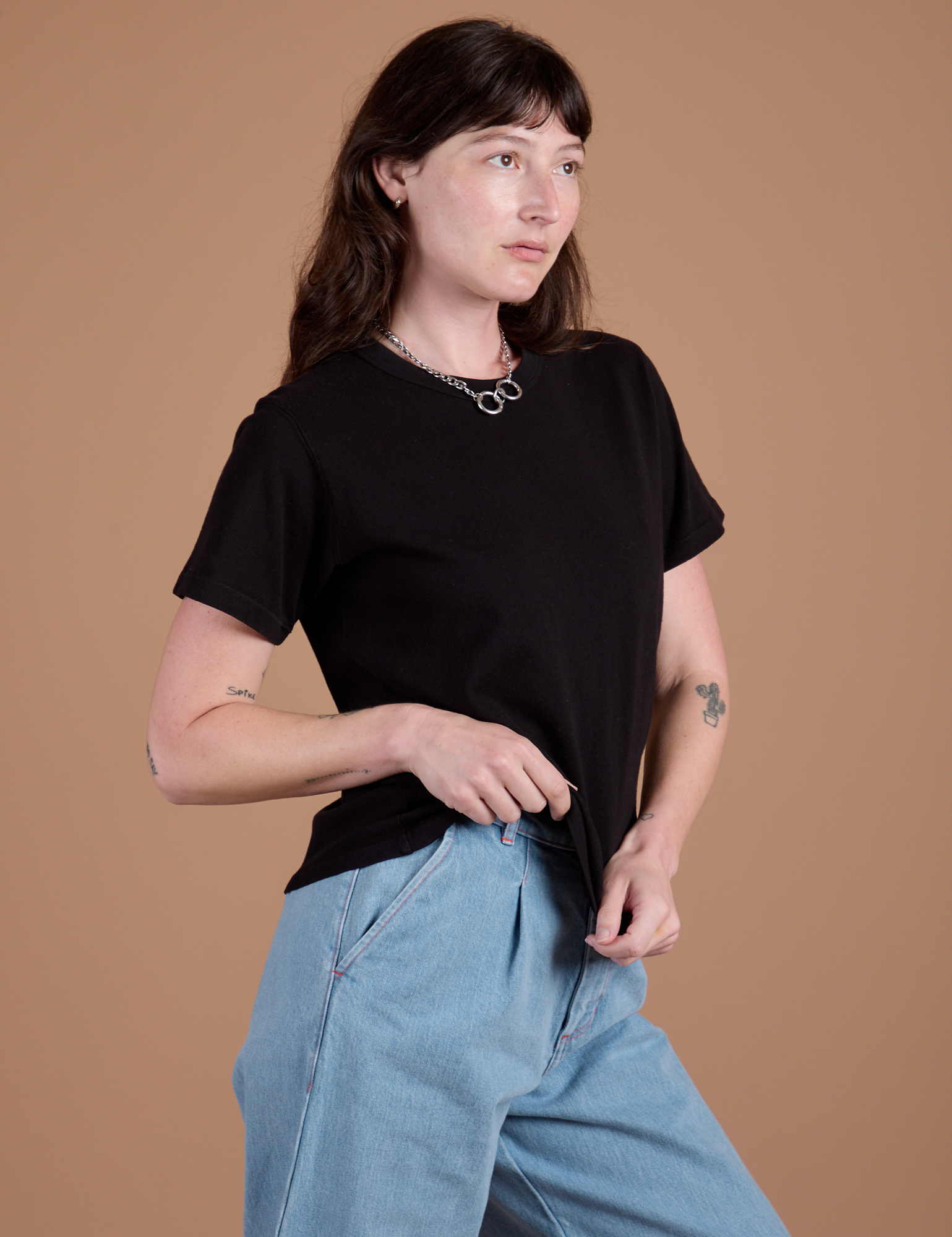 Angled front view of Burly Tee in Basic Black on Alex