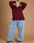 Juliet is 5'7" and wearing the Red Wine Long Sleeve Burly Tee with the Light Wash Wide Leg Denim Trousers