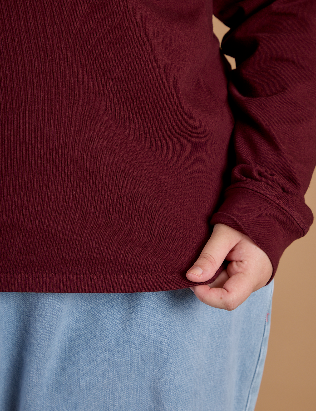 Close up of the hem on the Red Wine Long Sleeve Burly Tee worn by Juliet