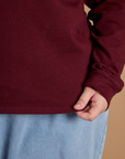Close up of the hem on the Red Wine Long Sleeve Burly Tee worn by Juliet