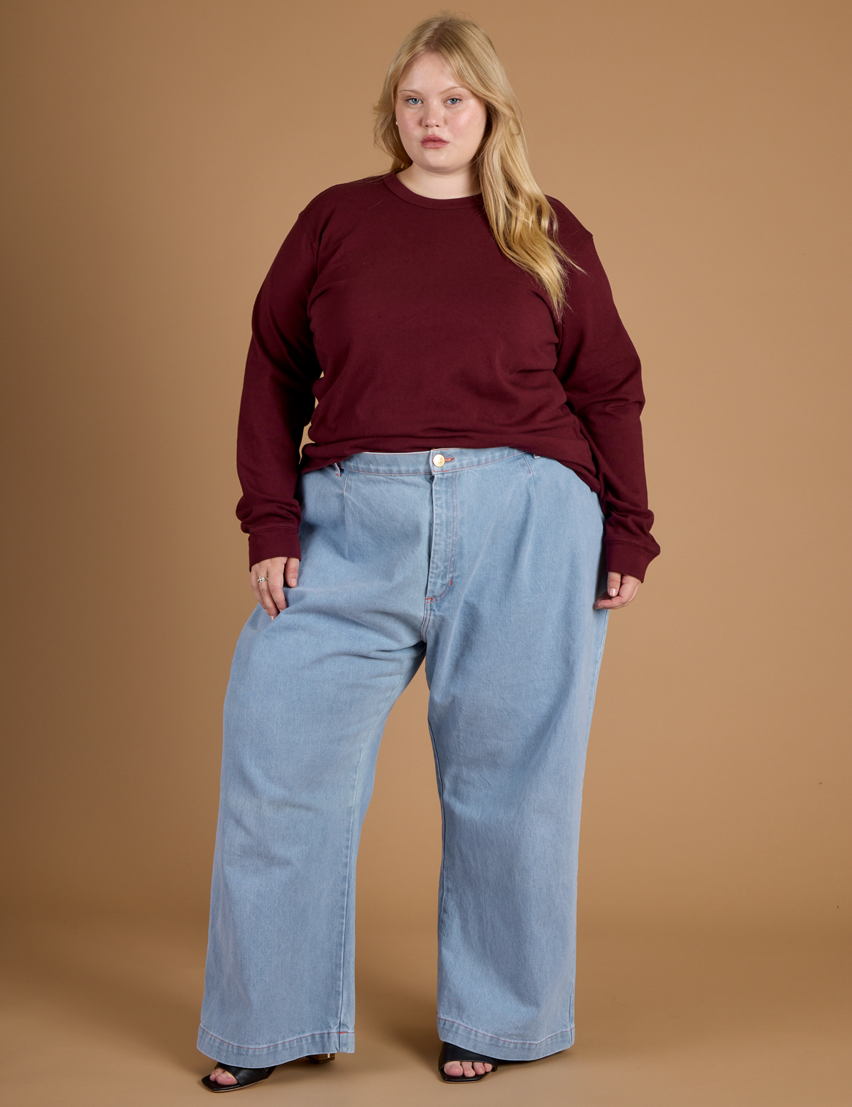 Juliet wearing the Red Wine Long Sleeve Burly Tee tucked into the Light Wash Wide Leg Denim Trousers