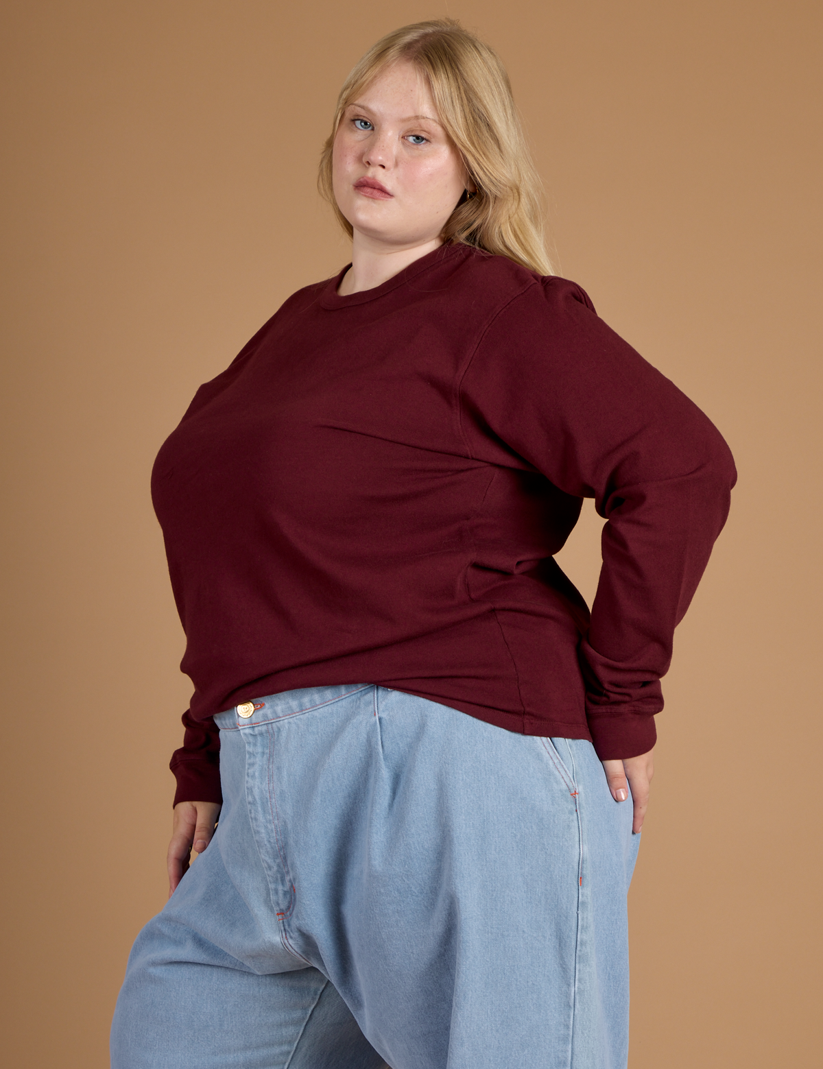 Juliet wearing the Red Wine Long Sleeve Burly Tee tucked into the Light Wash Wide Leg Denim Trousers