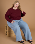 Juliet wearing the Red Wine Long Sleeve Burly Tee with Light Wash Wide Leg Denim Trousers