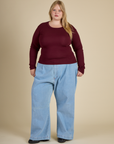 Juliet wearing the Red wine Long Sleeve Baby Tee with Light Wash Denim Wide Leg Trousers