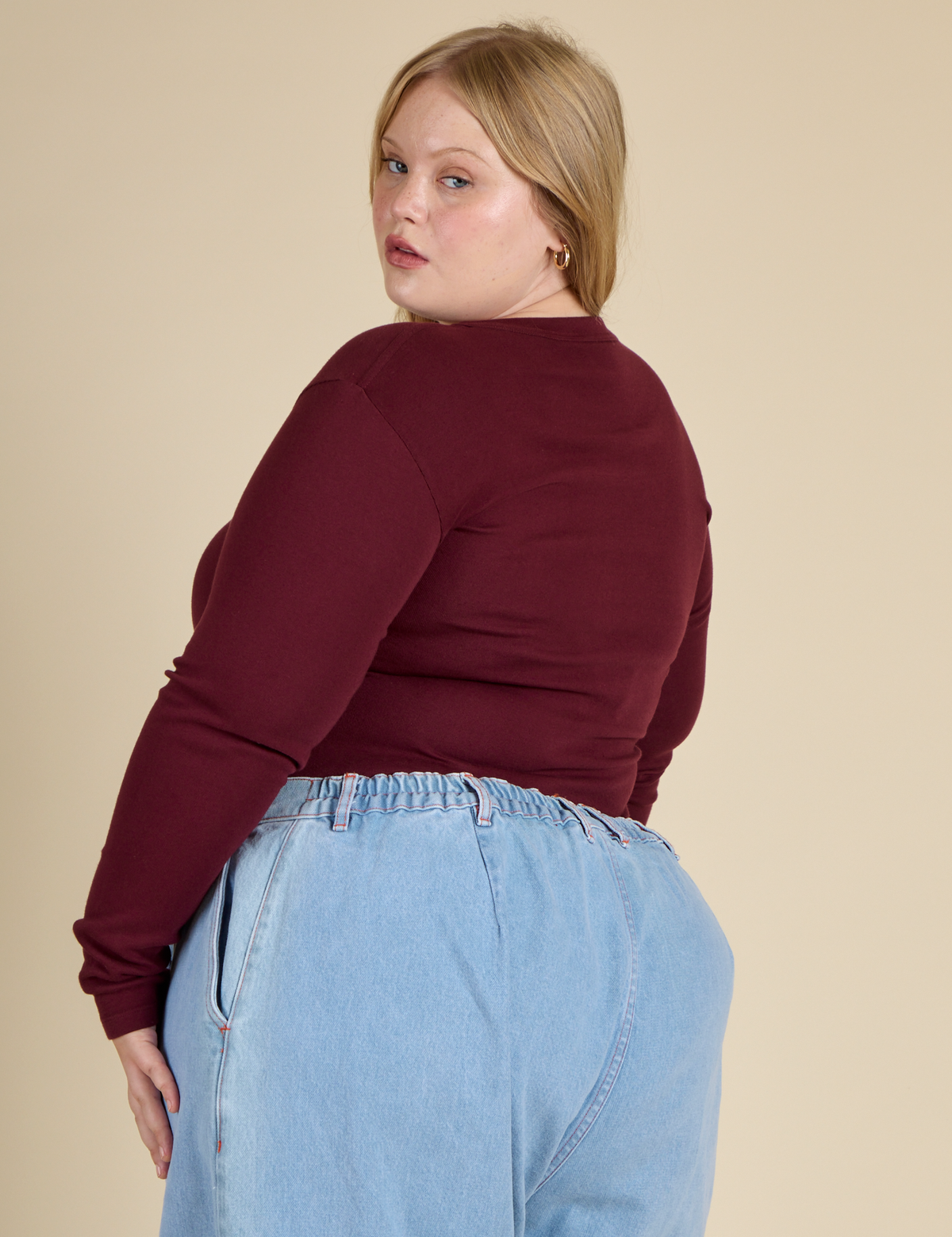Angled back view of Juliet in the Red wine Long Sleeve Baby Tee