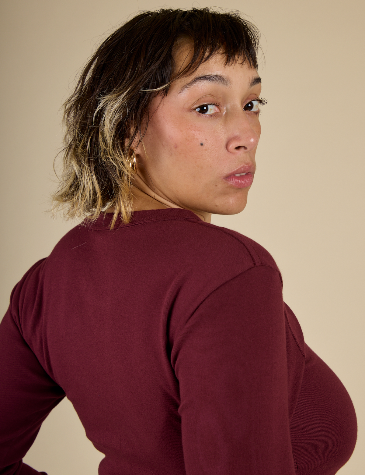 Close up angled back view of Mika wearing the Red wine Long Sleeve Baby Tee