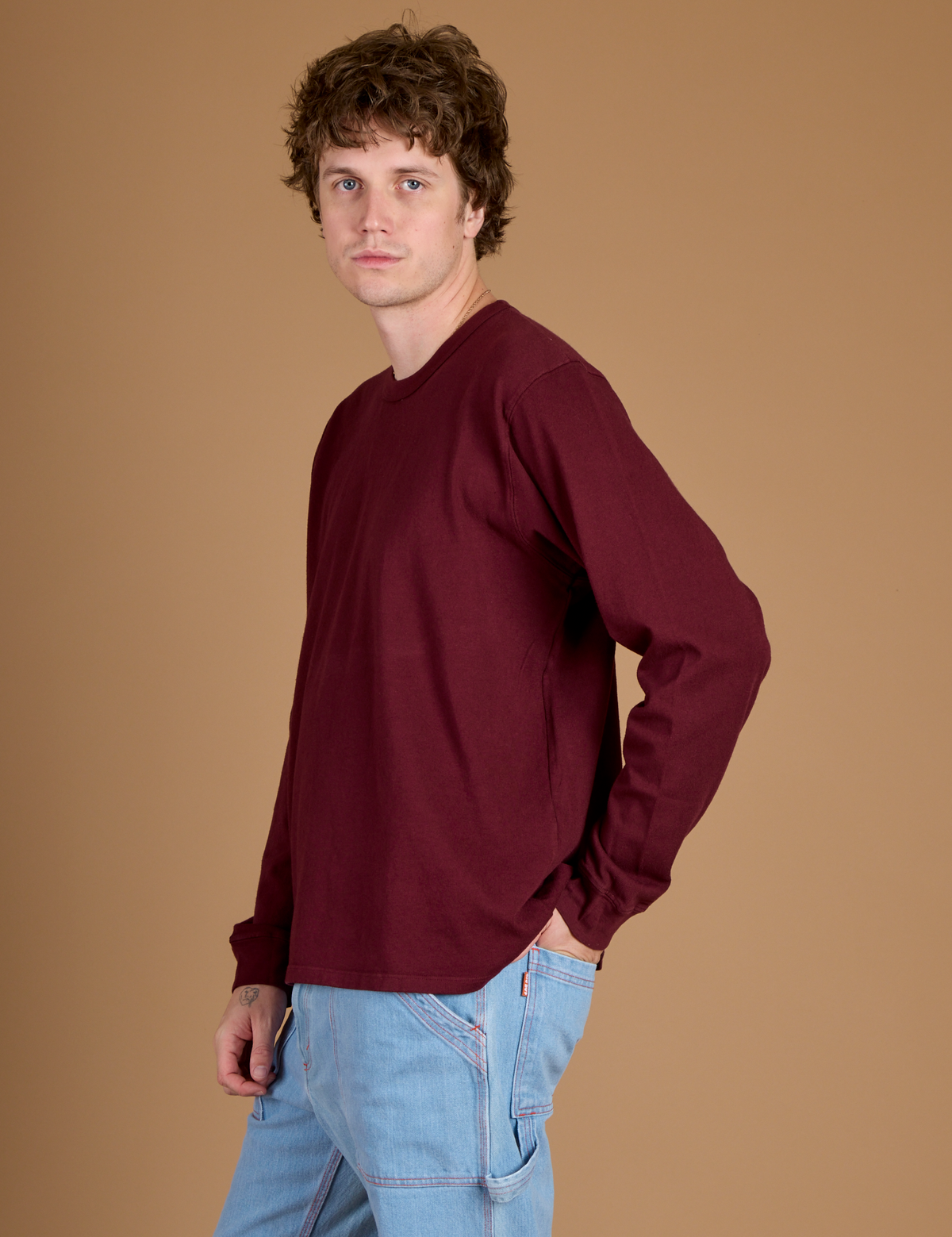 Side view of Quinn wearing the Red Wine Long Sleeve Burly Tee