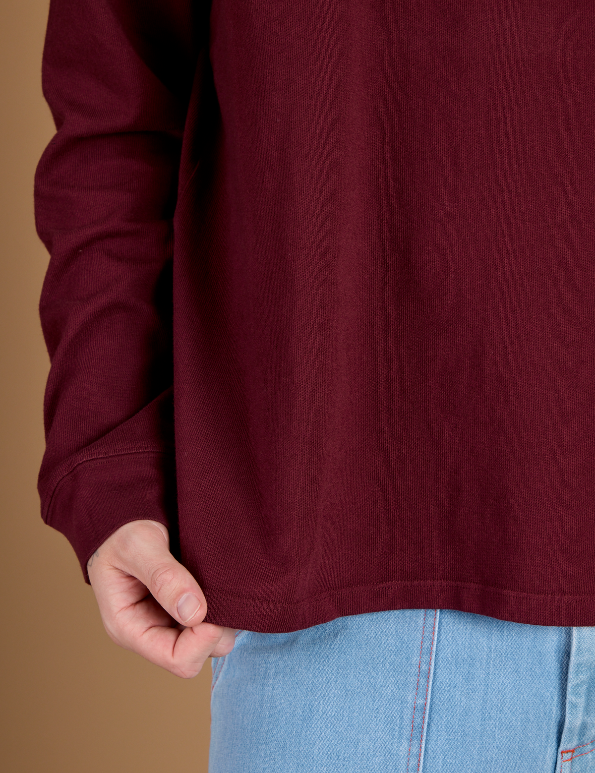Close up of the Hem on the Red Wine Long Sleeve Burly Tee worn by Quinn