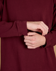 Close up of the Red Wine Long Sleeve Burly Tee's sleeves worn by Quinn