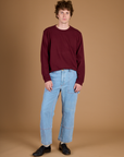 Quinn wearing the Red Wine Long Sleeve Burly Tee tucked into the Light Wash Carpenter Jeans